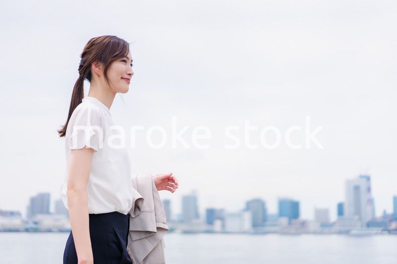 ジャケットを脱いで外を歩くビジネスウーマン