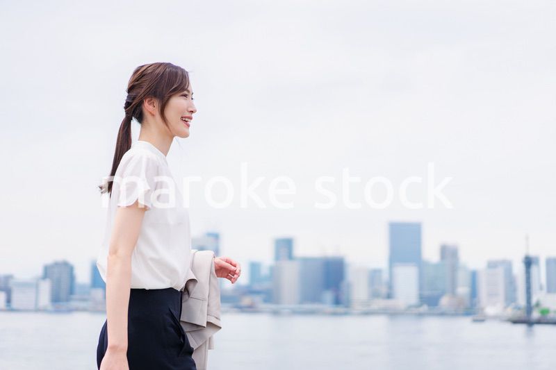 ジャケットを脱いで外を歩くビジネスウーマン