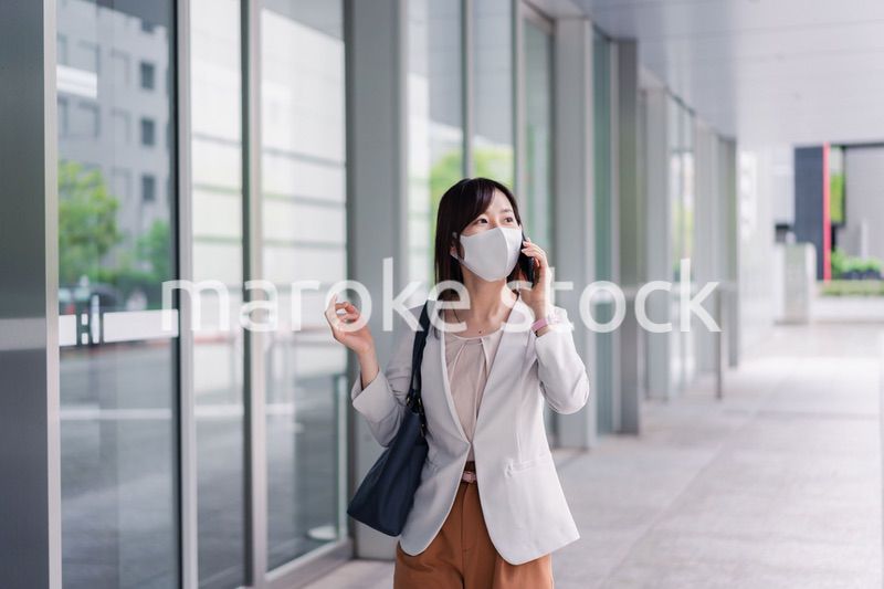 マスクをしてスマホを使う若い女性