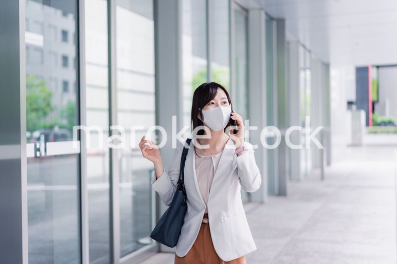 マスクをしてスマホを使う若い女性