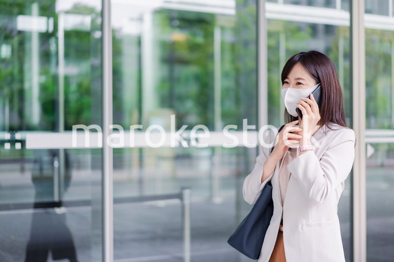マスクをしてスマホを使う若い女性