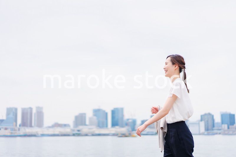 ジャケットを脱いで外を歩くビジネスウーマン