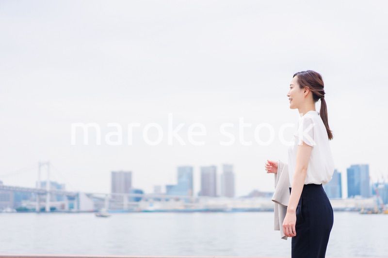 ジャケットを脱いで外を歩くビジネスウーマン