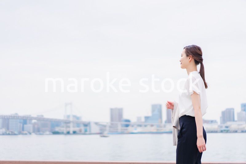 ジャケットを脱いで外を歩くビジネスウーマン