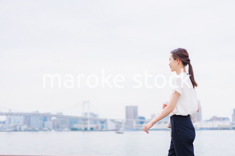 ジャケットを脱いで外を歩くビジネスウーマン