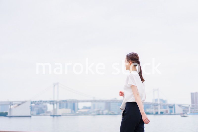 ジャケットを脱いで外を歩くビジネスウーマン