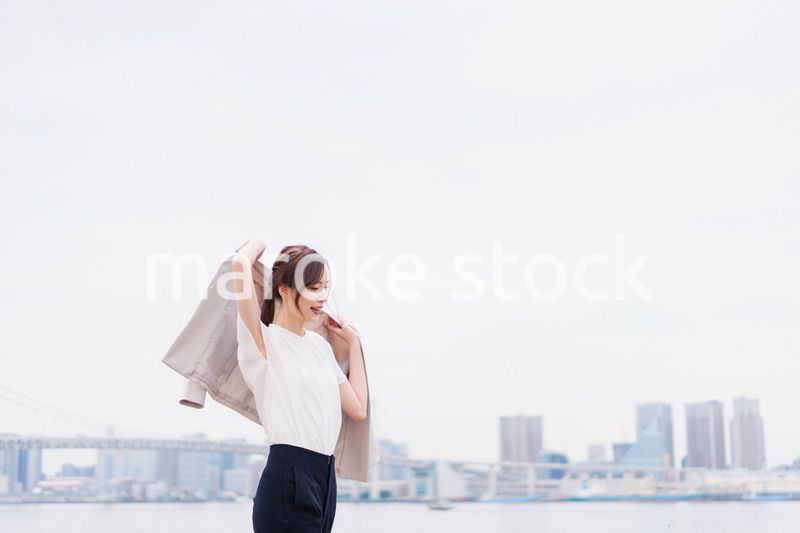 都会でジャケットを脱ぐビジネスウーマン