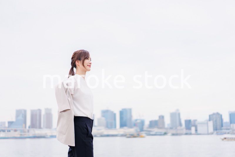 都会でジャケットを脱ぐビジネスウーマン