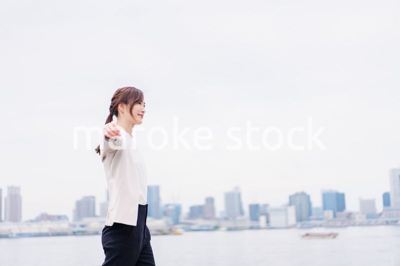 都会でジャケットを脱ぐビジネスウーマン