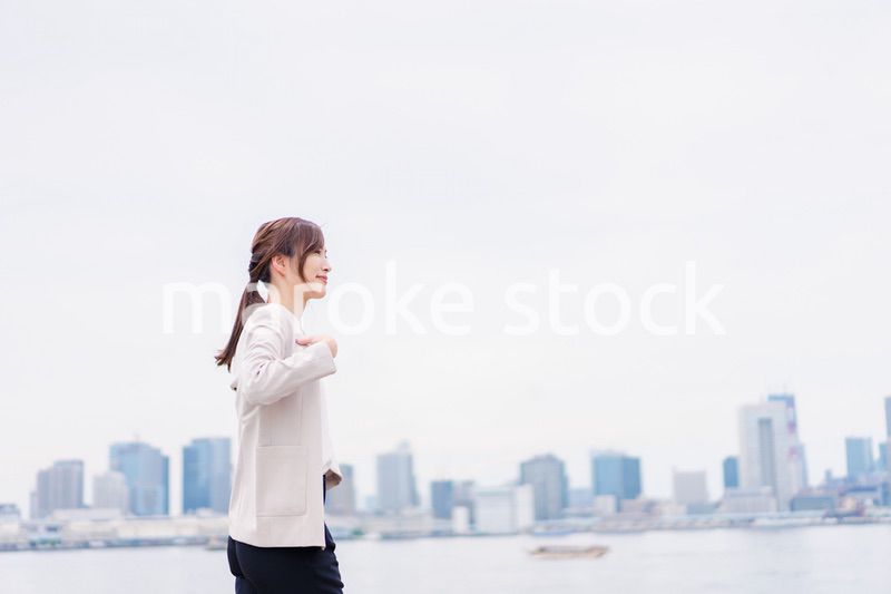 都会でジャケットを脱ぐビジネスウーマン