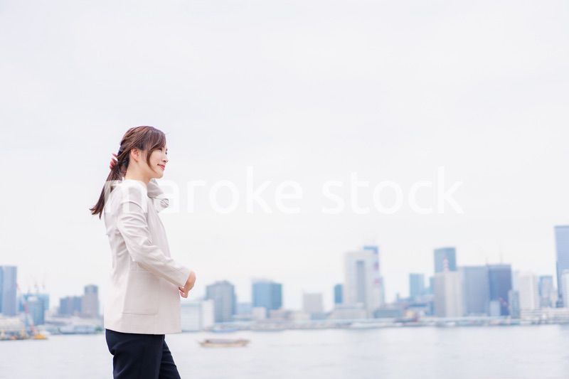 都会でジャケットを脱ぐビジネスウーマン