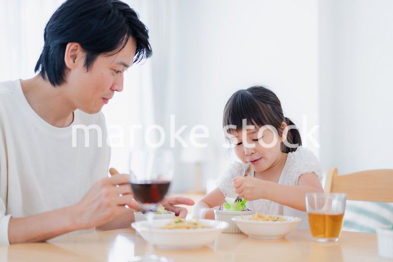 パパと一緒にご飯を食べる小さな女の子