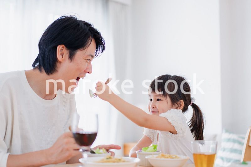 パパと一緒にご飯を食べる小さな女の子