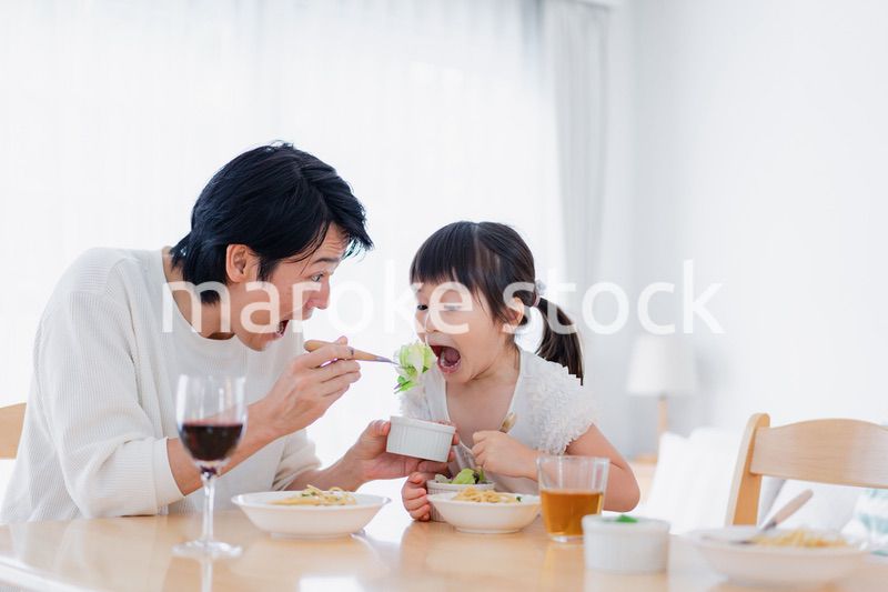 パパと一緒にご飯を食べる小さな女の子