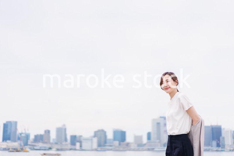 都会でジャケットを脱ぐビジネスウーマン