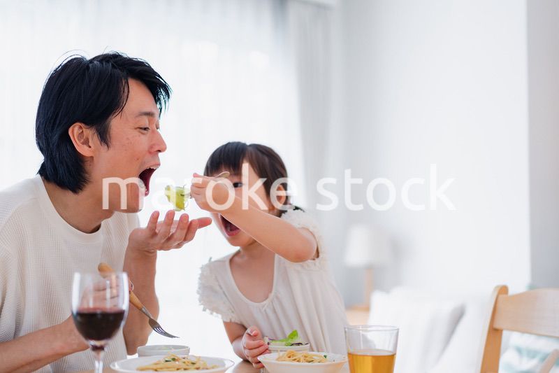 パパと一緒にご飯を食べる小さな女の子