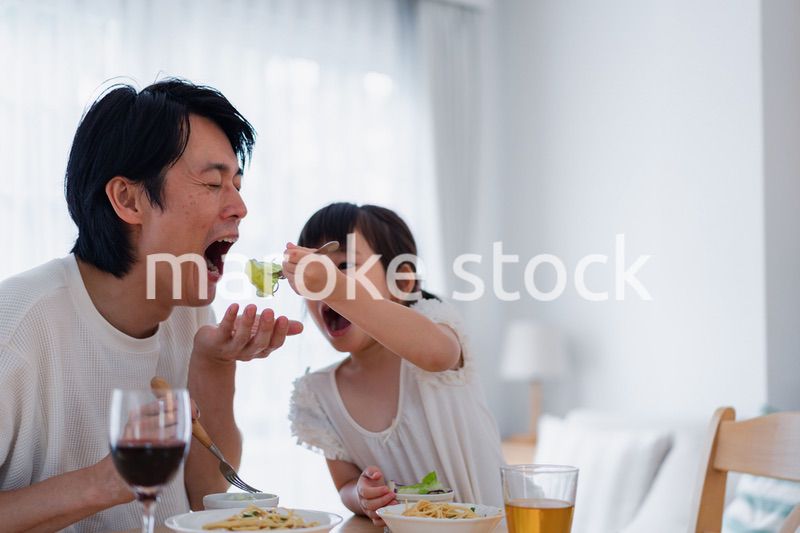 パパと一緒にご飯を食べる小さな女の子