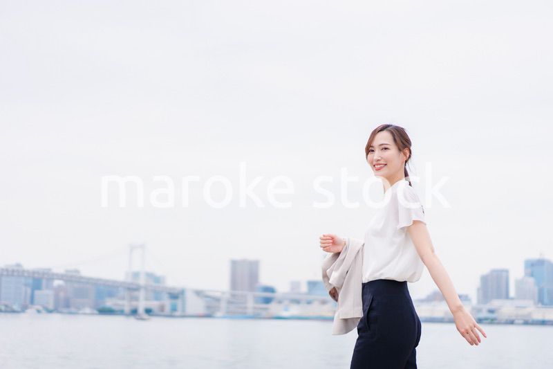 ジャケットを脱いで外を歩くビジネスウーマン