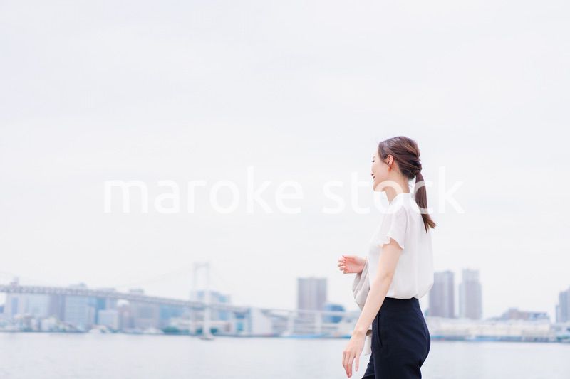 ジャケットを脱いで外を歩くビジネスウーマン