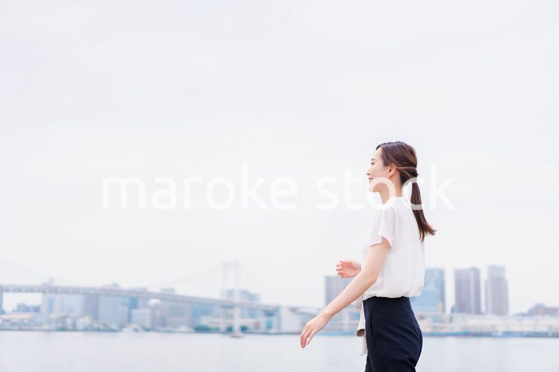 ジャケットを脱いで外を歩くビジネスウーマン