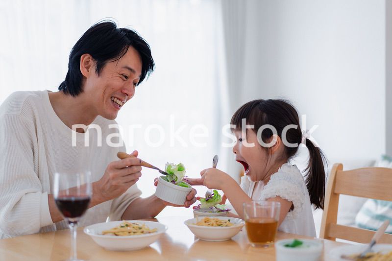 パパと一緒にご飯を食べる小さな女の子