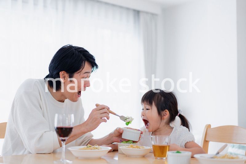 パパと一緒にご飯を食べる小さな女の子