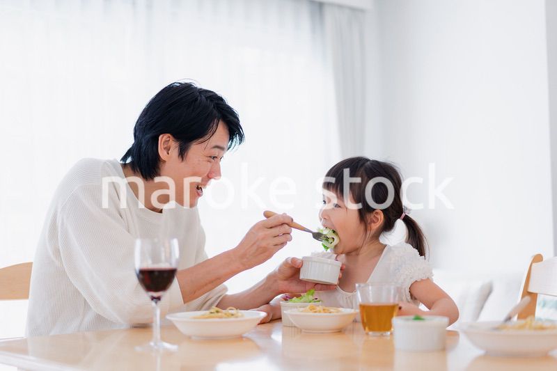 パパと一緒にご飯を食べる小さな女の子