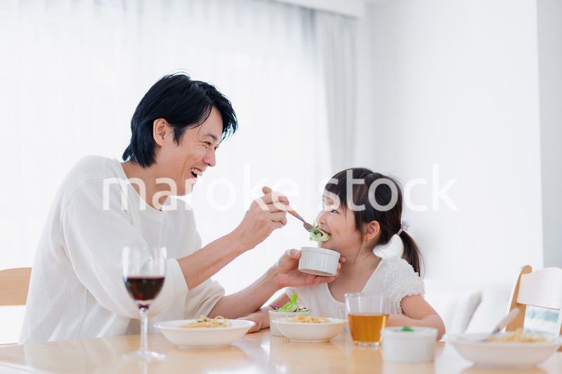 パパと一緒にご飯を食べる小さな女の子