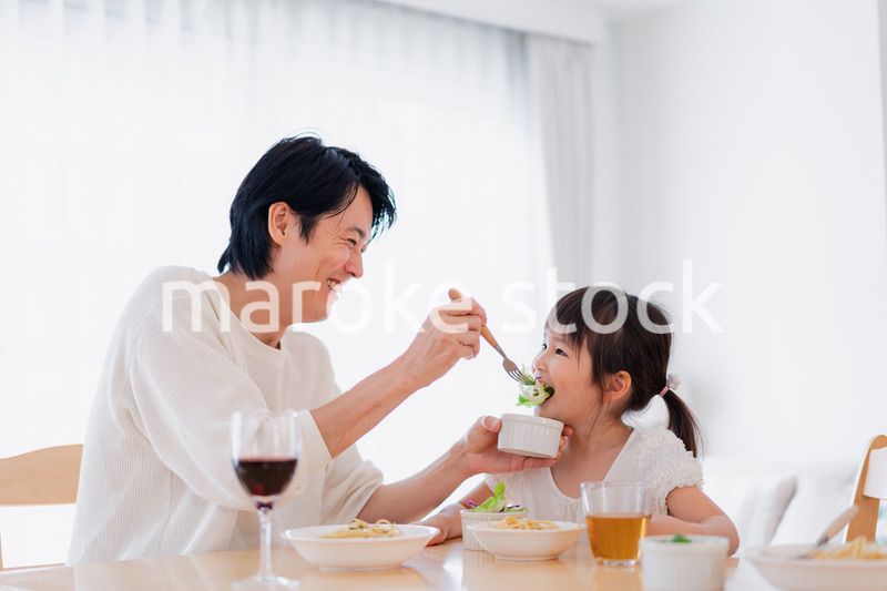 パパと一緒にご飯を食べる小さな女の子