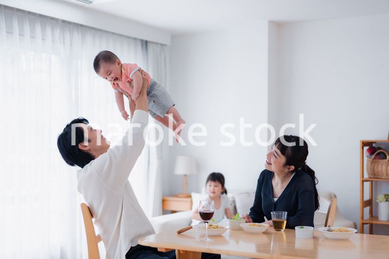 赤ちゃんに高い高いをするお父さん