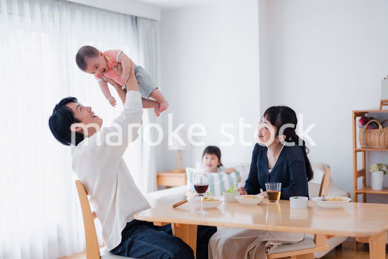 赤ちゃんに高い高いをするお父さん