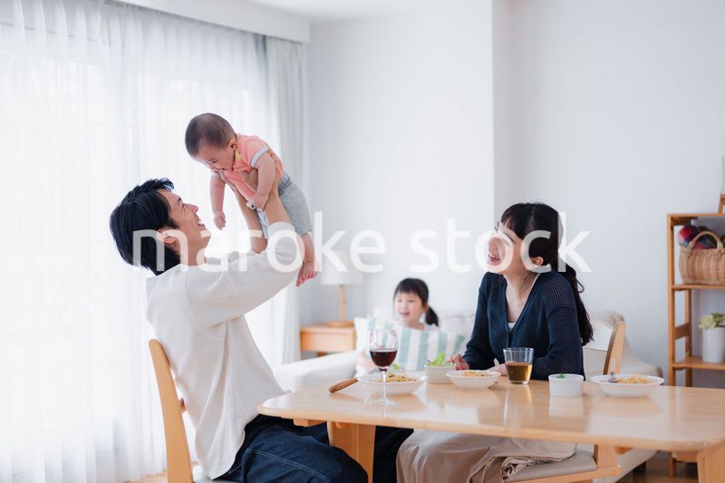 赤ちゃんに高い高いをするお父さん