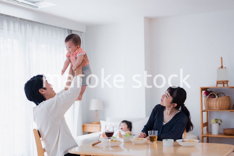 赤ちゃんに高い高いをするお父さん