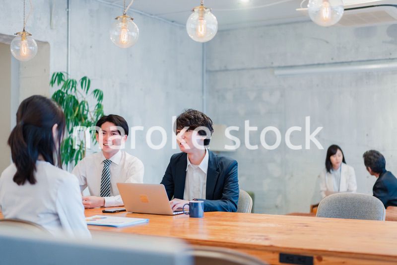 明るいオフィスに勤務をするビジネスパーソン