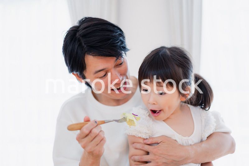 パパと一緒にご飯を食べる小さな女の子