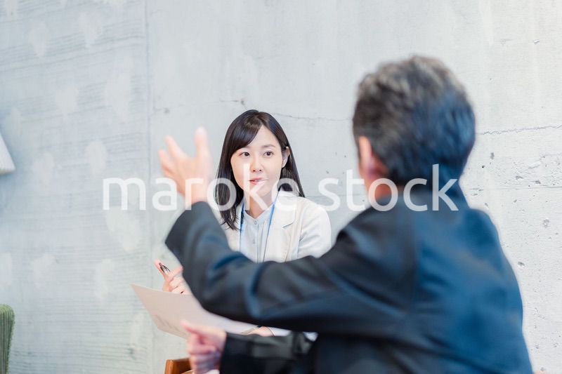 ビジネスマンに保険の勧誘をする営業の女性