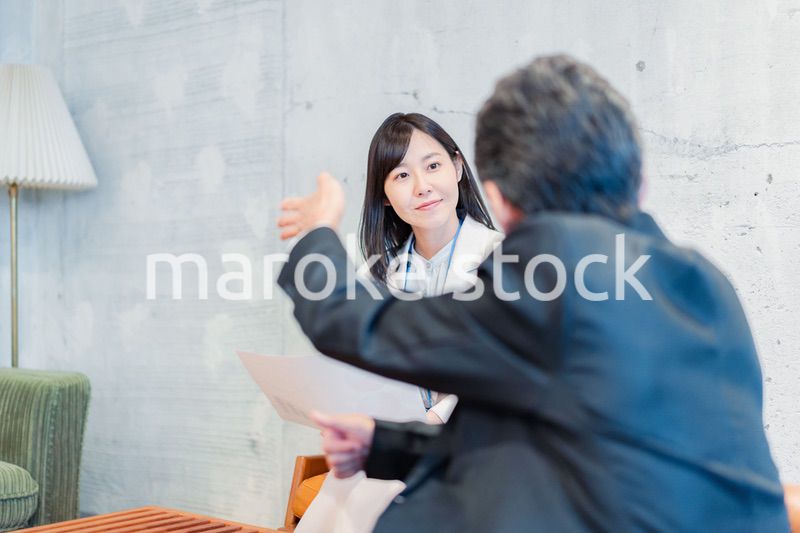 ビジネスマンに保険の勧誘をする営業の女性