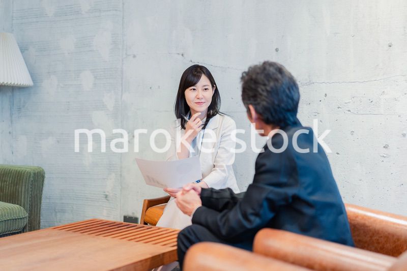 ビジネスマンに保険の勧誘をする営業の女性