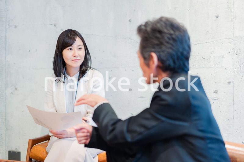 ビジネスマンに保険の勧誘をする営業の女性