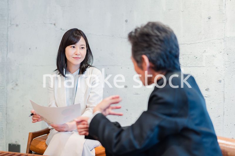 ビジネスマンに保険の勧誘をする営業の女性