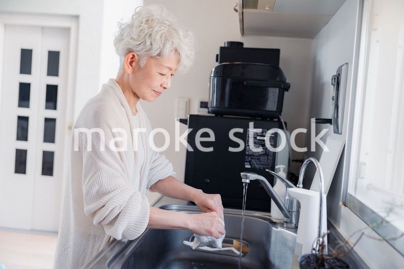 キッチンで洗い物をするシニア女性