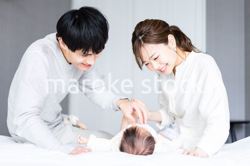 赤ちゃんをあやす若い夫婦
