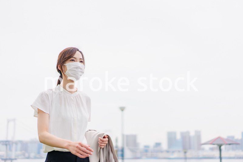 マスクをして都会を歩くビジネスウーマン