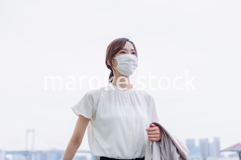 マスクをして都会を歩くビジネスウーマン