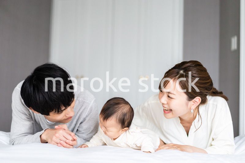 赤ちゃんと一緒に寝転ぶファミリー
