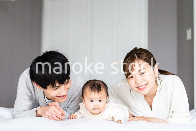 赤ちゃんと一緒に寝転ぶファミリー