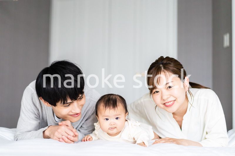 赤ちゃんと一緒に寝転ぶファミリー