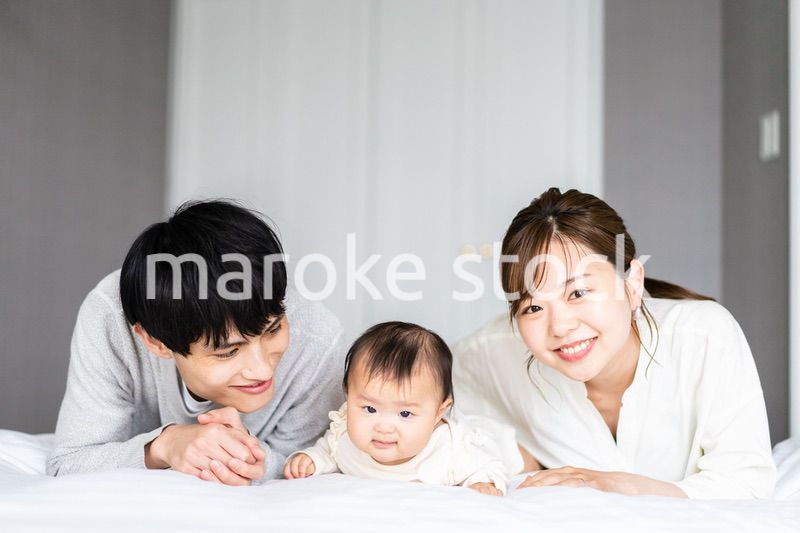 赤ちゃんと一緒に寝転ぶファミリー