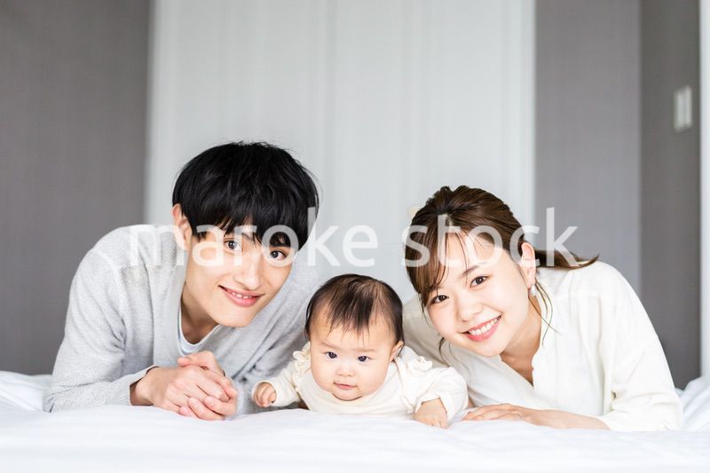 赤ちゃんと一緒に寝転ぶファミリー