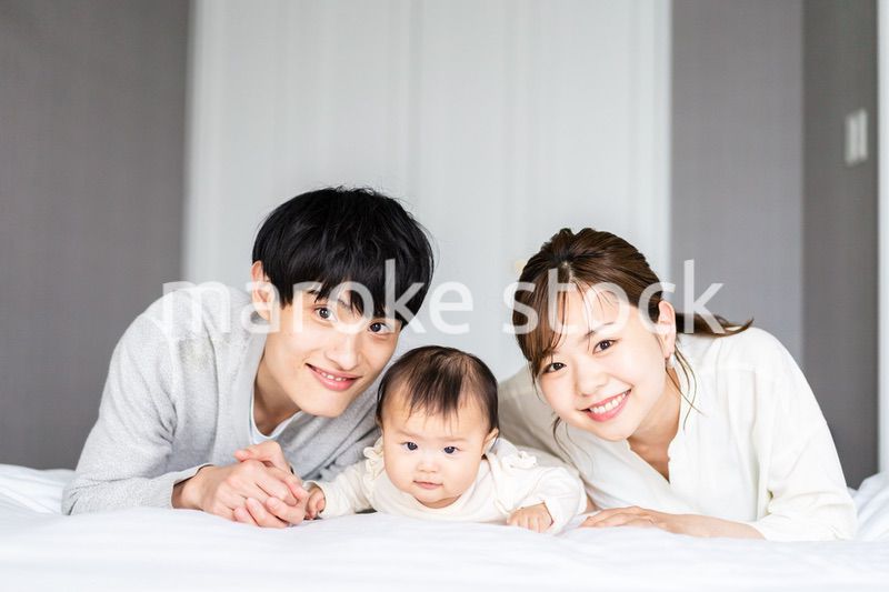 赤ちゃんと一緒に寝転ぶファミリー